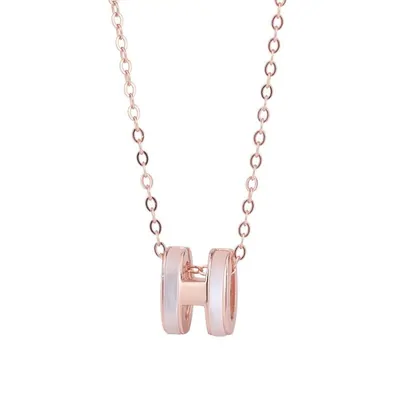 A rose gold chain necklace with a short cylindrical pendant, photographed on white