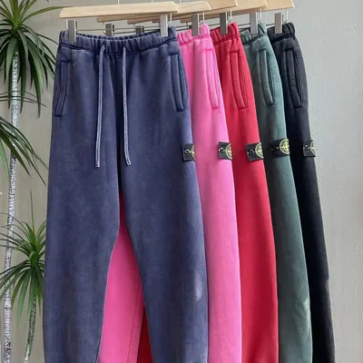 A rail of velvet joggers in indigo, pink, green and charcoal, each with a drawstring waist
